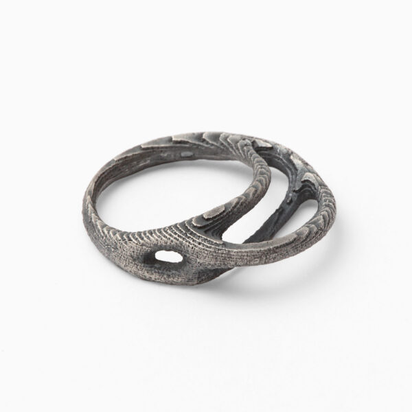 Extravagantní dámský prsten Kořen z patinovaného stříbra. Atypický tvar prstenu je inspirován přírodními ději růstu a zvětrávání. Tmavá patina umocňuje luxusní vyznění přírodní struktury povrchu.